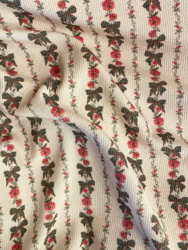 Fabric with floral and bow pattern on a striped background